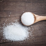 sugar in a wooden spoon on wooden plank